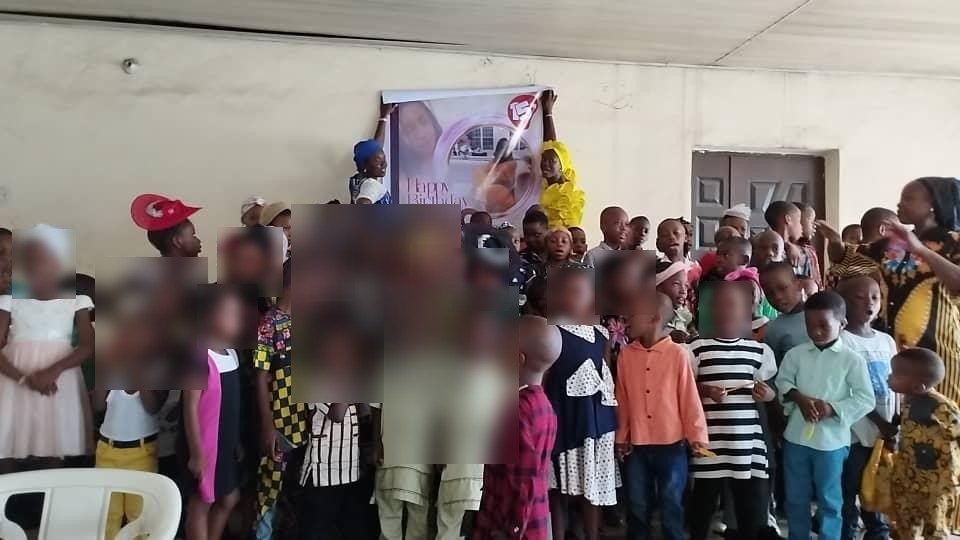 Children gathered indoors with the HCCO banner