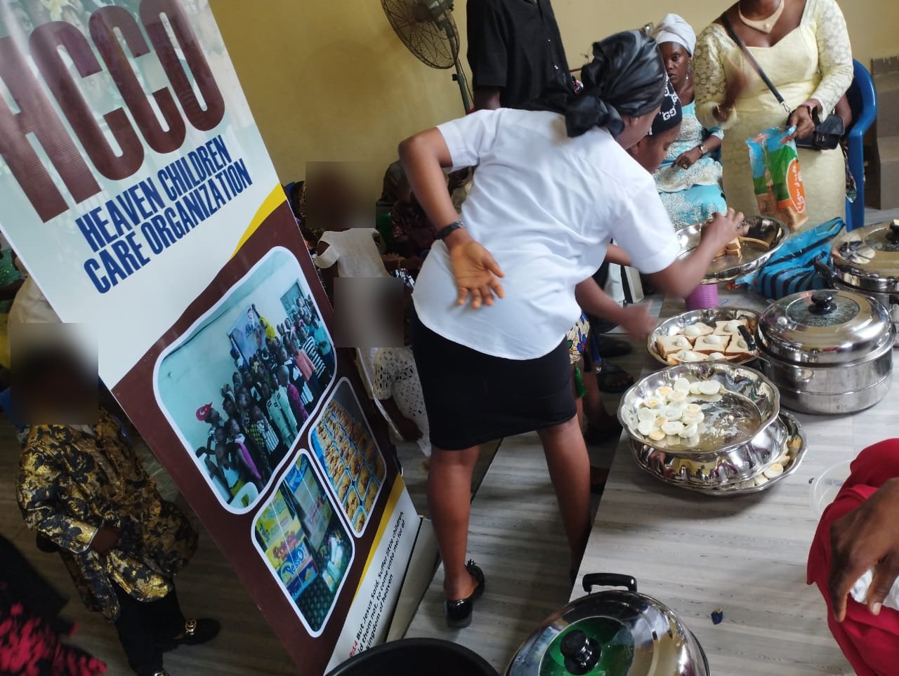 Volunteers serving food to children at an HCCO event